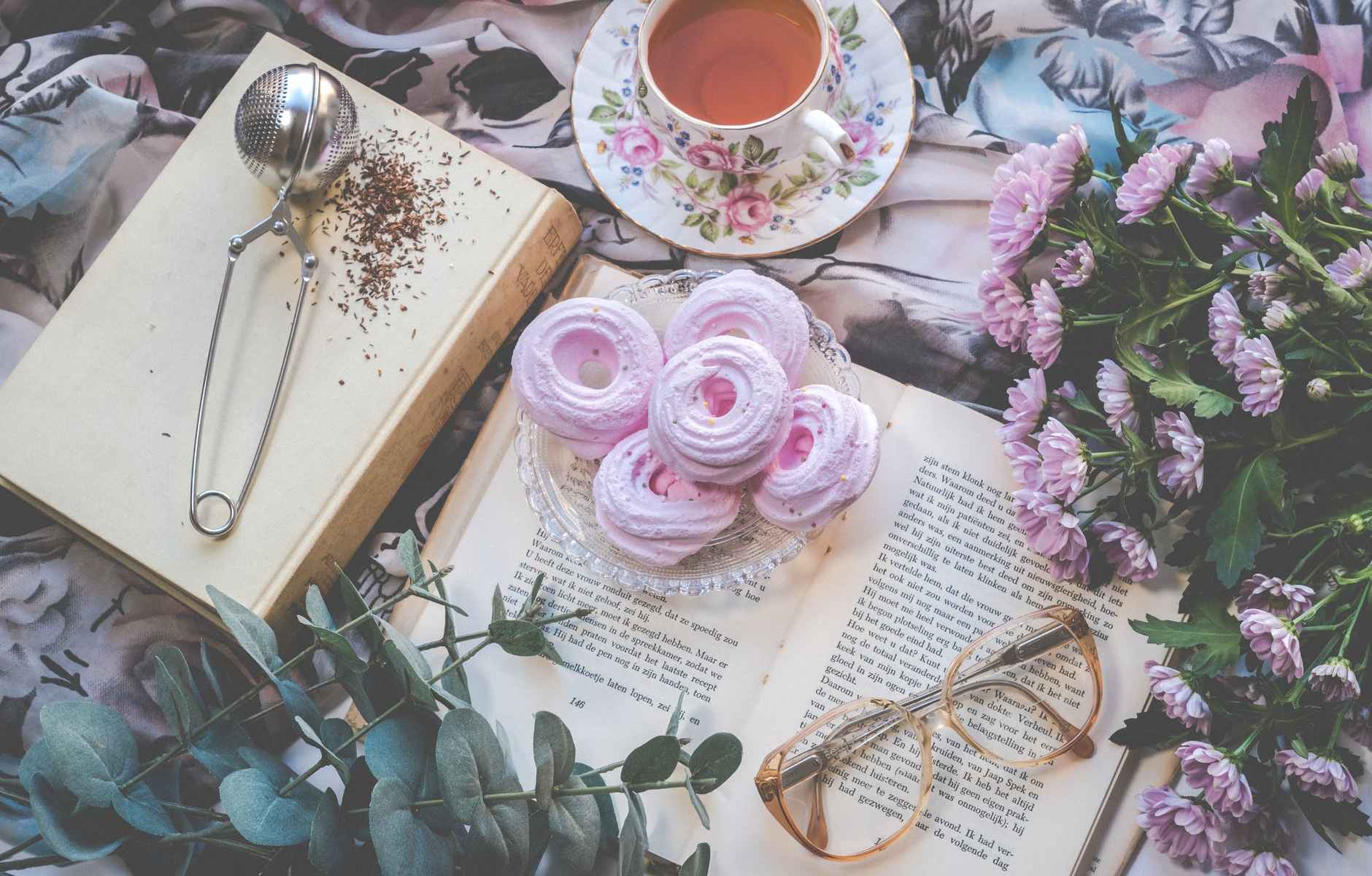 floral ceramic cup and saucer above open book